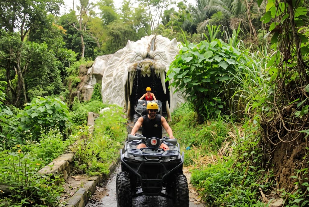 A rider in a yellow helmet leaving the lion-head tunnel on the Sedang ATV track