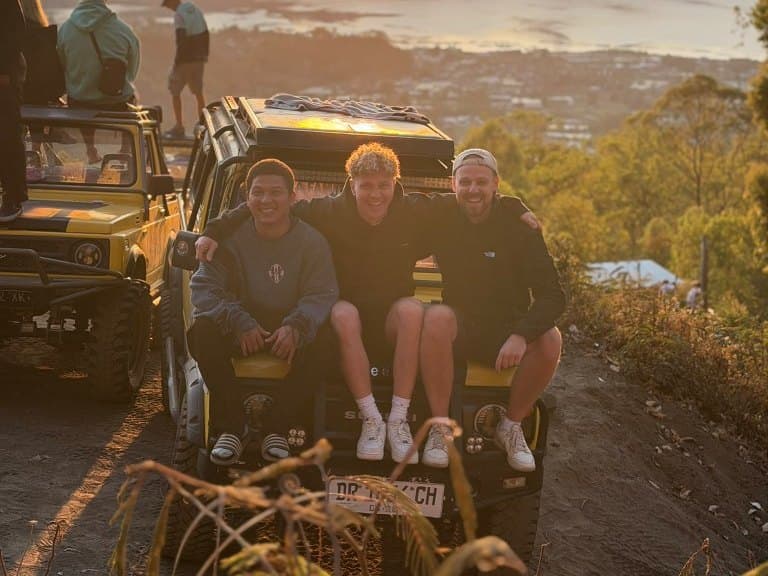 バトゥール山のサンライズ展望地で、貸切ジープのボンネットに座る3人の友人
