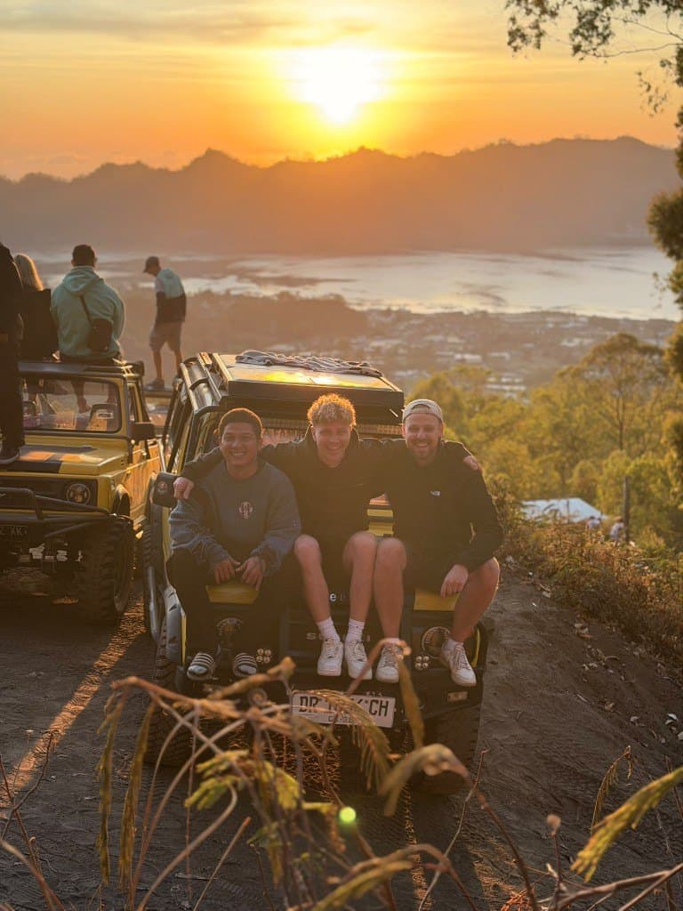 Three guests and their driver on the jeep bonnet at the Batur sunrise viewpoint