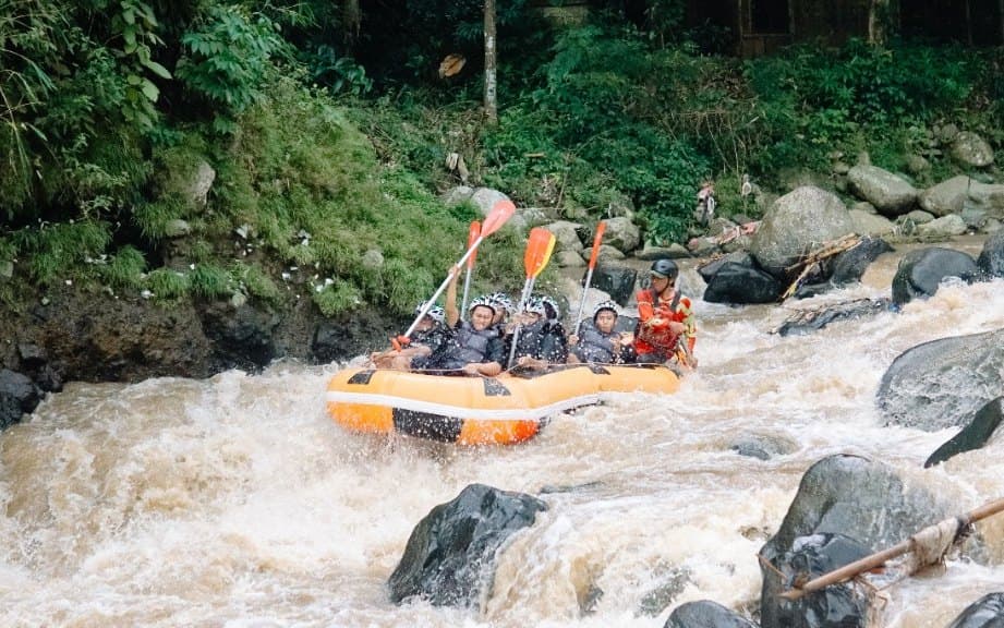 Un équipage de rafting lève ses pagaies dans un rapide de la rivière Ayung