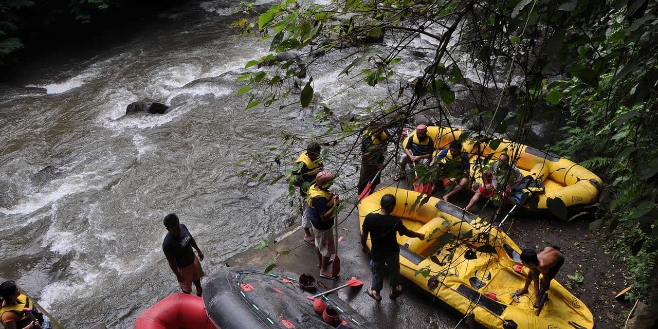 Yellow rafts and paddlers at a rafting base on the bank of the Ayung River near Ubud